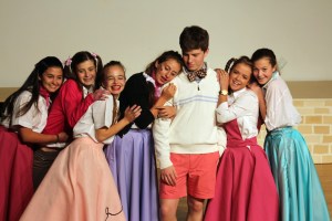 Sarah F. (center), playing Kim McAfee, is joined by her girlfriends as they swoon over Hugo, played by Connor H., in the musical number "One Boy" during the production of Bye Bye Birdie. 
